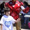 Iron Hero explains hero training to boy at a character appearance in Conroe for the Autism Awareness Walk.
